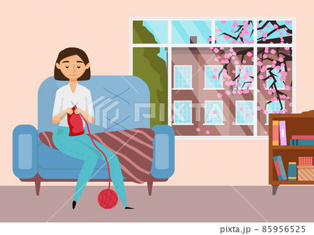 Young girl is engaged in knitting. Woman having fun making warm clothes while sitting on an armchair 85956525