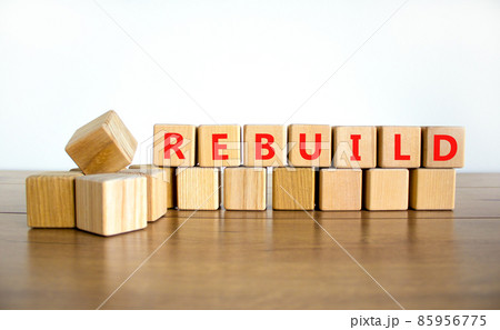 Rebuild and build symbol. The concept word Rebuild on wooden cubes. Beautiful wooden table, white background, copy space. Business rebuild and build concept. 85956775
