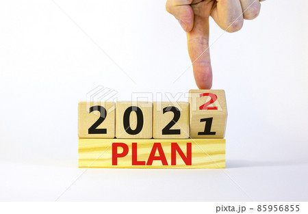 2022 plan new year symbol. Businessman turns a wooden cube and changes words 'Plan 2021' to 'Plan 2022'. Beautiful white background, copy space. Business, 2022 plan new year concept. 2022 plan new year symbol. Businessman turns a wooden cube and changes words 'Plan 2021' to 'Plan 2022'. Beautiful white background, copy space. Business, 2022 plan new year concept. 85956855