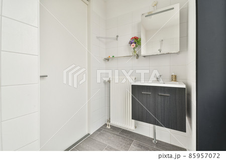 Sink with tap and liquid soap under mirror in contemporary restroom at home 85957072