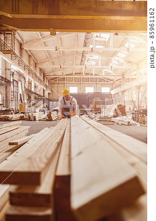 Male builder checking wooden planks at construction site Male builder checking wooden planks at construction site 85961162