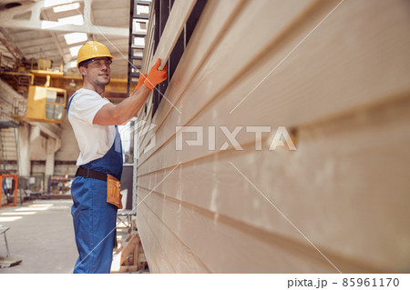 Cheerful worker building module house at construction site 85961170