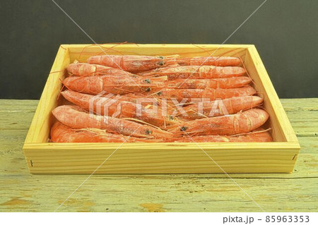 Red cooked shrimps on black and white background in wooden box . Low angle view and copy space. Marine food Red cooked shrimps on black and white background in wooden box . Low angle view and copy space. Marine food 85963353