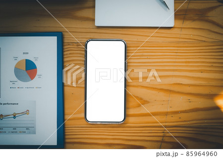 Mock up mobile phone white screen with financial chart on wooden desk . Blank screen for your advertising. 85964960