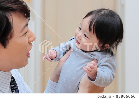 赤ちゃんを抱っこする会社員のパパ 赤ちゃんを抱っこする会社員のパパ 85966666