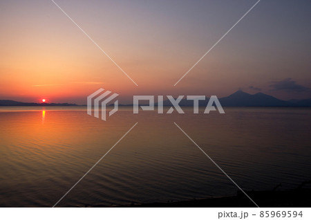 福島県、猪苗代湖の夕景。夕日が空と湖面をオレンジ色に染め、磐梯山のシルエットが綺麗 85969594