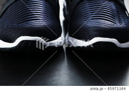 Black and white ultra-modern sports sneakers on a black background. 85971164