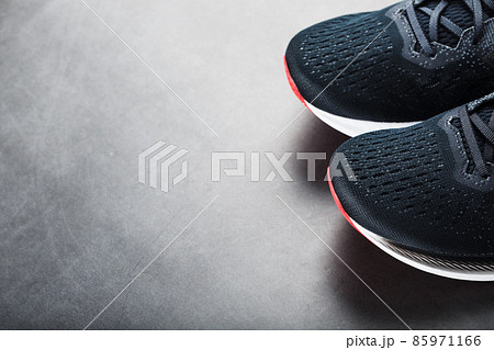 Black running shoes with mesh and black laces close-up on a dark background Black running shoes with mesh and black laces close-up on a dark background 85971166