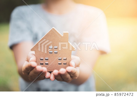 Small home model on woman hand. Family life and business real estate concept. 85972472