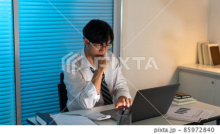 Overwork Concept The office employee sitting at the office desk and holding his chin with the left hand while brainstorming his idea on his work Overwork Concept The office employee sitting at the office desk and holding his chin with the left hand while brainstorming his idea on his work 85972840