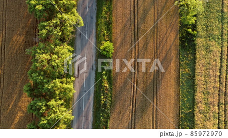 Aerial drone view flight over asphalt road with green trees Aerial drone view flight over asphalt road with green trees 85972970