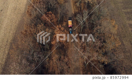 Aerial Drone View Flight Over Blue Tractor With Trailer Filled Yellow Corn Grain 85972994