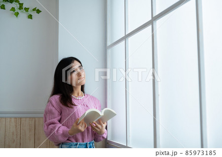 窓辺で読書をする若い女性 85973185