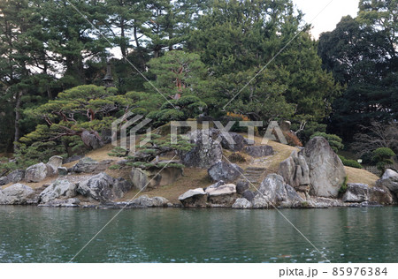 冬の栗林公園、南湖周遊の和船からの眺め。（弁財天を祀る天女嶋の石組み、上陸のための石段が見える） 85976384
