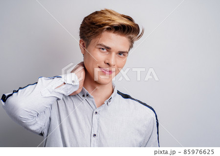 handsome young guy wearing shirt while looking at camera and smiling. Stylish man's hairstyle. handsome young guy wearing shirt while looking at camera and smiling. Stylish man's hairstyle. 85976625
