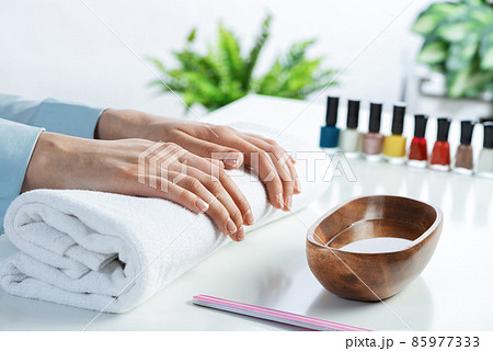 Female hands lying on white towel Female hands lying on white towel 85977333