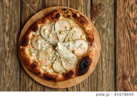 Pizza with pears and Gorgonzola cheese, italian pizza with pear and blue cheese on a wooden background Pizza with pears and Gorgonzola cheese, italian pizza with pear and blue cheese on a wooden background 85978609