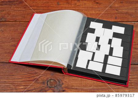 Postage stamps frames set in vintage album on wooden table Postage stamps frames set in vintage album on wooden table 85979317