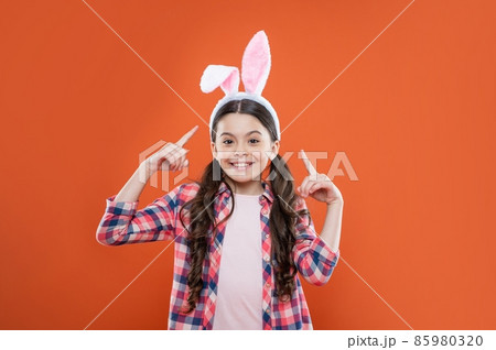 happy teen girl pointing finger on funny bunny ears for easter holiday, happy easter 85980320
