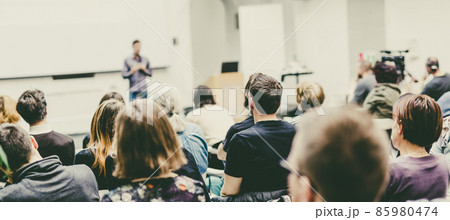 Man giving presentation in lecture hall at university. 85980474