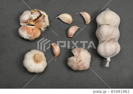 Garlic isolated on black stone background. Garlic isolated on black stone background. 85981962