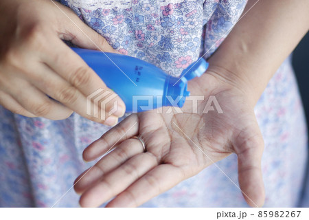 women pouring hair oil on hand close up women pouring hair oil on hand close up 85982267