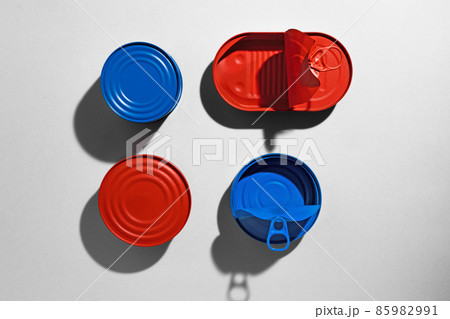 Red and blue painted tin cans on gray background Red and blue painted tin cans on gray background 85982991
