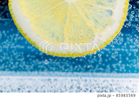 Lemon close-up. Slice of lemon, mineral bubbles. lemonade Lemon close-up. Slice of lemon, mineral bubbles. lemonade 85983569