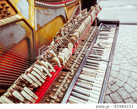 Fragment of an old broken and peeling piano with missing parts 85984233
