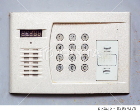 White metal intercom on a light gray wall. Close-up photo White metal intercom on a light gray wall. Close-up photo 85984279