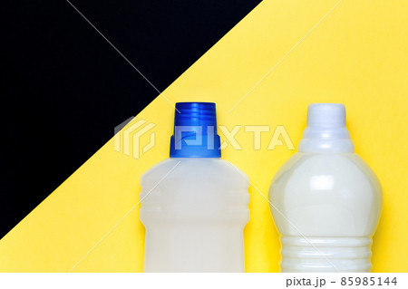 Mockup cleaning detergent in a bottle on a bright yellow black background with copy space. Household chemicals for sanitation and housework. Packaging for goods top view 85985144