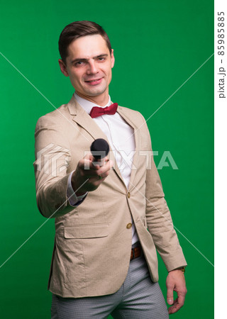 Portrait of professional male reporter holding a microphone, isolated on white and green background Portrait of professional male reporter holding a microphone, isolated on white and green background 85985885