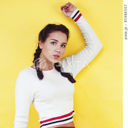 lifestyle people concept: pretty young school teenage girl having fun happy smiling on yellow background 85986507