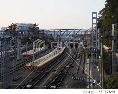 View of the railway station with rails, platforms and trains against the backdrop of the cityscape View of the railway station with rails, platforms and trains against the backdrop of the cityscape 85987844