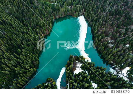 Synevyr lake in the Carpathians, top view of the lake, mountain lake covered with ice, ice line on Synevyr lake. Synevyr lake in the Carpathians, top view of the lake, mountain lake covered with ice, ice line on Synevyr lake. 85988370