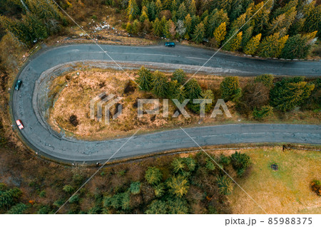 steep and dangerous turns on the road, serpentine roads in the woods, top view of the serpentine and forest. steep and dangerous turns on the road, serpentine roads in the woods, top view of the serpentine and forest. 85988375