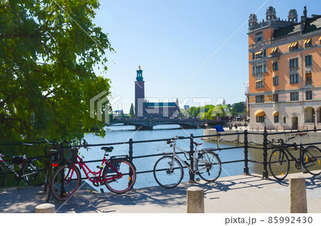 Watercolor drawing of Bikes near bridge railing and Stockholm City Hall Stadshuset tower building of Municipal Council 85992430
