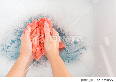 Female hands washing color clothes in sink 85994055
