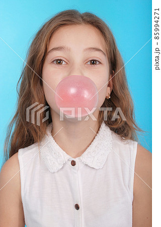 Girl blowing a big bubble gum bubble 85994271