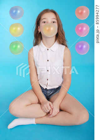 Young girl making a big bubble with a chewing gum Young girl making a big bubble with a chewing gum 85994277