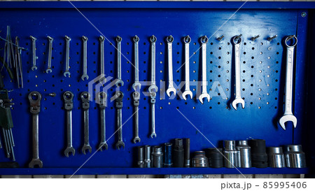 A mechanic's set of screwdrivers hangs on the wall. 85995406