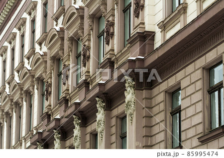 Detail image of facade of an old building. Windows and decoration of walls made in old style. Unique architecture 85995474