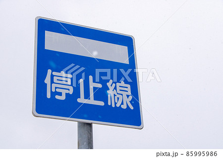 雪が降る日の道路標識(指示標識)「停止線」。 85995986