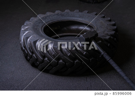 A tire on a black background with a sledgehammer lies for crosfit fitness wheel sledgehammer workout black sport, In the afternoon athlete gym for lifestyle concentration physical, big club. Sweat A tire on a black background with a sledgehammer lies for crosfit fitness wheel sledgehammer workout black sport, In the afternoon athlete gym for lifestyle concentration physical, big club. Sweat 85996006