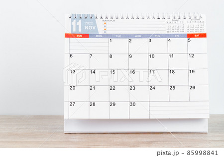 November 2022 desk calendar on wooden table. 85998841