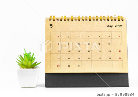 May 2022 Desk calendar with plant pot on white table. 85998934