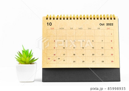 October 2022 Desk calendar with plant pot on white table. 85998935
