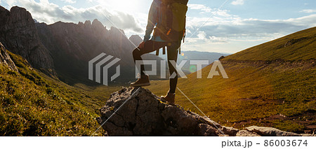 Solo woman backpacker hiking on alpine mountain peak Solo woman backpacker hiking on alpine mountain peak 86003674