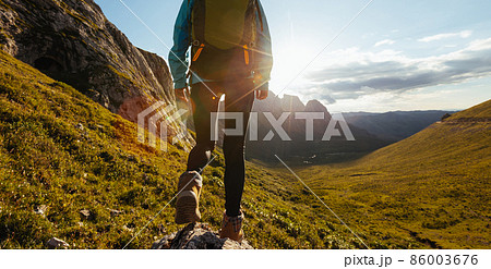Solo woman backpacker hiking on alpine mountain peak Solo woman backpacker hiking on alpine mountain peak 86003676