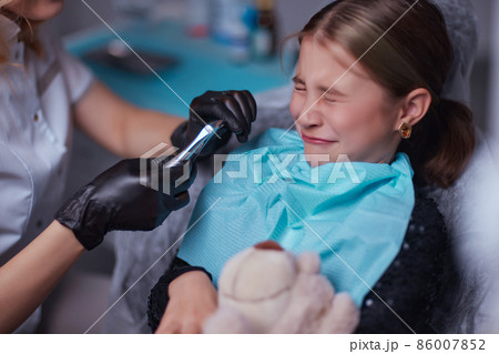 Dentist use anesthetic injection for tooth extraction in child. 86007852